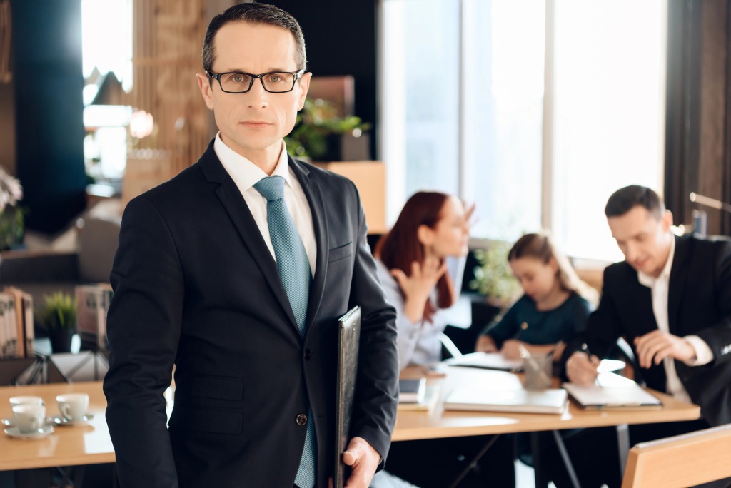 Family lawyer in suit standing in front of family in office